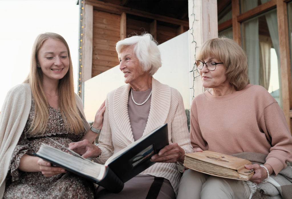 three generations of women looking through scrapbooks together estate planning